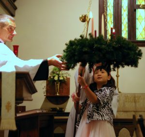 An Acolyte Helps Children Participate in an Advent Service